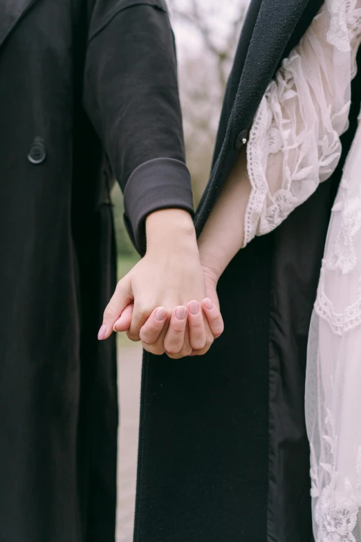 a close up of two people holding hands, an album cover, pexels, romanticism, lightly dressed, asian women, orthodox, leaked photo