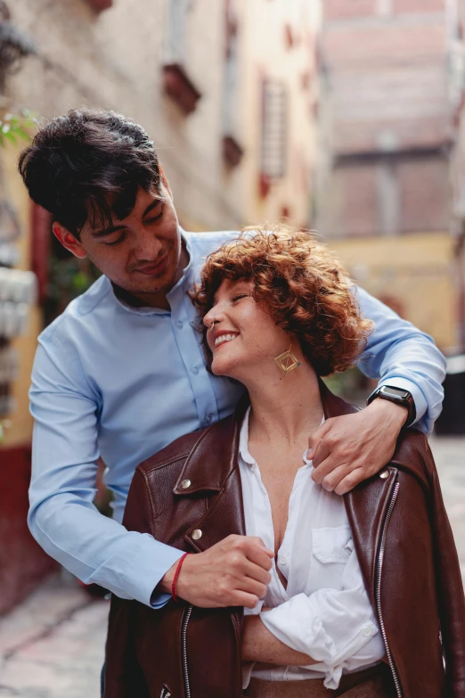 a man and a woman standing next to each other, an album cover, pexels contest winner, riccardo scamarcio, at a city street, embracing, curly and short top hair