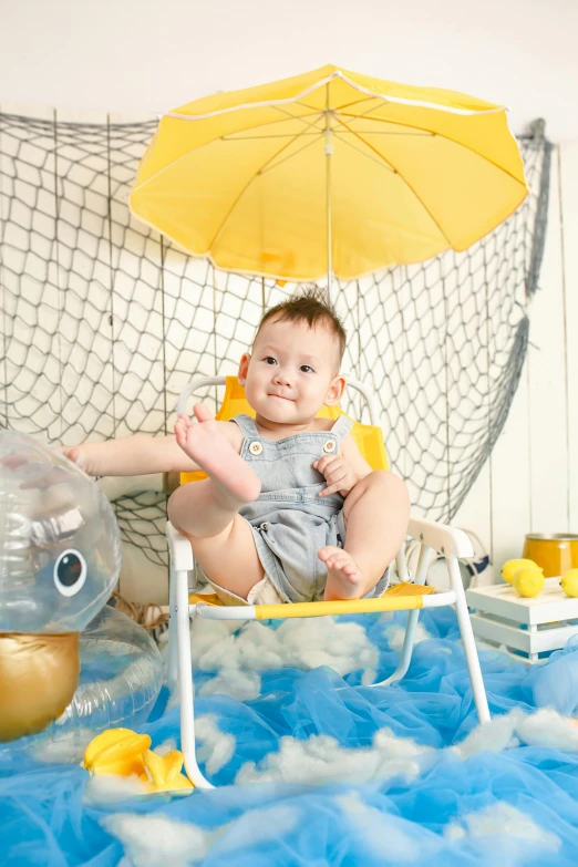 a baby sitting in a chair with an umbrella, silver and yellow color scheme, deep sea themed, lookbook, softplay