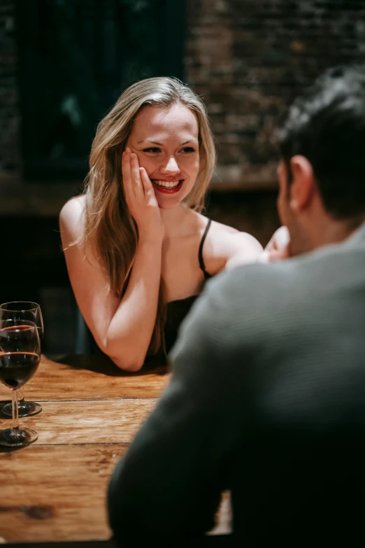 a man and a woman sitting at a table with wine glasses, cheeky smile, sydney sweeney, man proposing his girlfriend, mid night