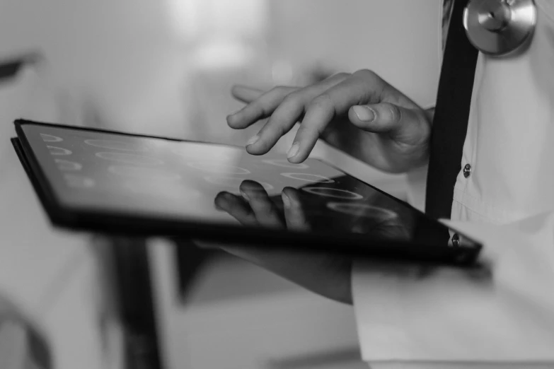 a close up of a person holding a tablet, a black and white photo, by Adam Marczyński, working, touch, uploaded, monitor