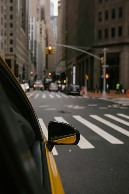 a taxi driving down a city street next to tall buildings, pexels contest winner, new jersey, tail fin, reflective lens, contemplating