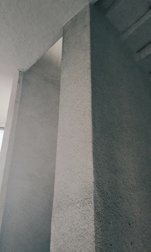 a man flying through the air while riding a skateboard, by Pablo Rey, concrete art, low quality photo, 4 k detail, standing in corner of room, made of cement and concrete