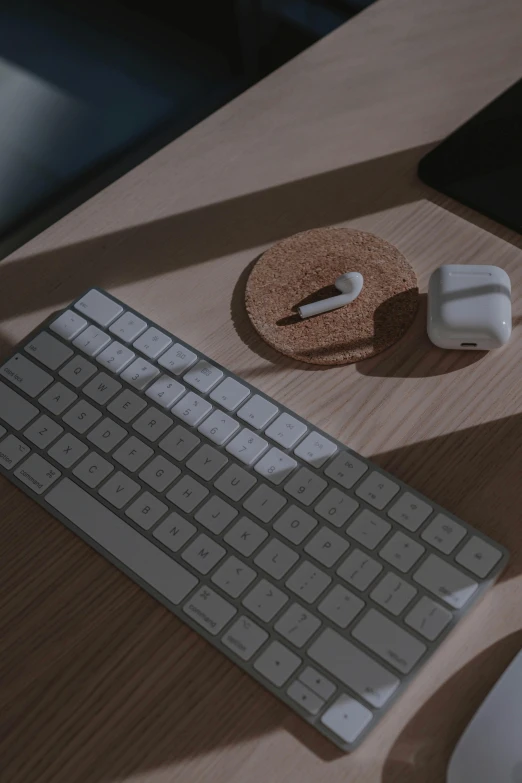 a computer keyboard sitting on top of a wooden desk, airpods, detailed product image, beautifully detailed render, simple aesthetic