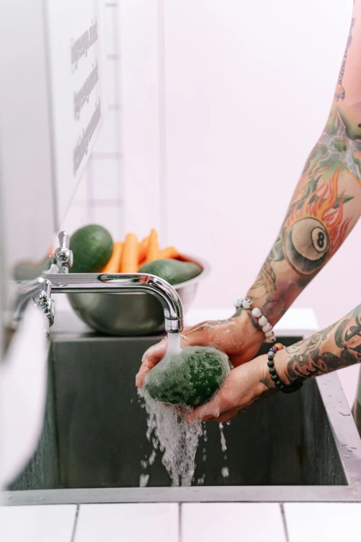 a tattooed man washing vegetables in a kitchen sink, a tattoo, by Jessie Alexandra Dick, trending on unsplash, commercial washroom hand dryer, greens, soap carving, plain background