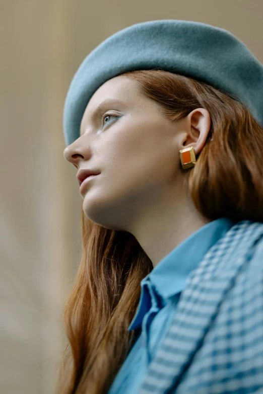 a woman with long red hair wearing a blue hat, trending on pexels, an earring, inspired in balthus, squares, refined editorial photograph