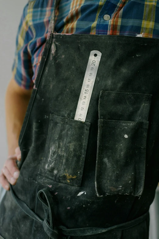 a close up of a person wearing an apron, blacksmith apron, sense of scale, tools, measurements