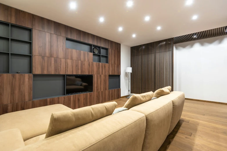 a living room filled with furniture and a flat screen tv, a 3D render, pexels contest winner, recessed, brown wood cabinets, minimalist lighting, gold and luxury materials