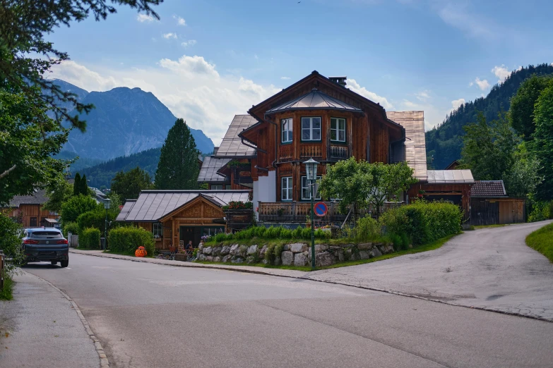 a large house sitting on the side of a road, by Franz Hegi, pexels contest winner, chalet, tiled roofs, summer day, high quality photo