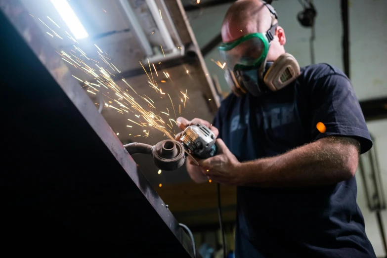 a man grinding a piece of metal with a grinder, by Matthias Stom, pexels contest winner, arbeitsrat für kunst, avatar image, profile picture, australian, worksafe. instagram photo