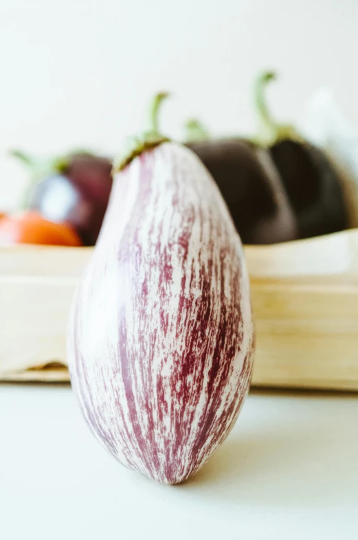 a close up of an eggplant on a table, renaissance, white and purple, zoomed in, full product shot, large cornicione