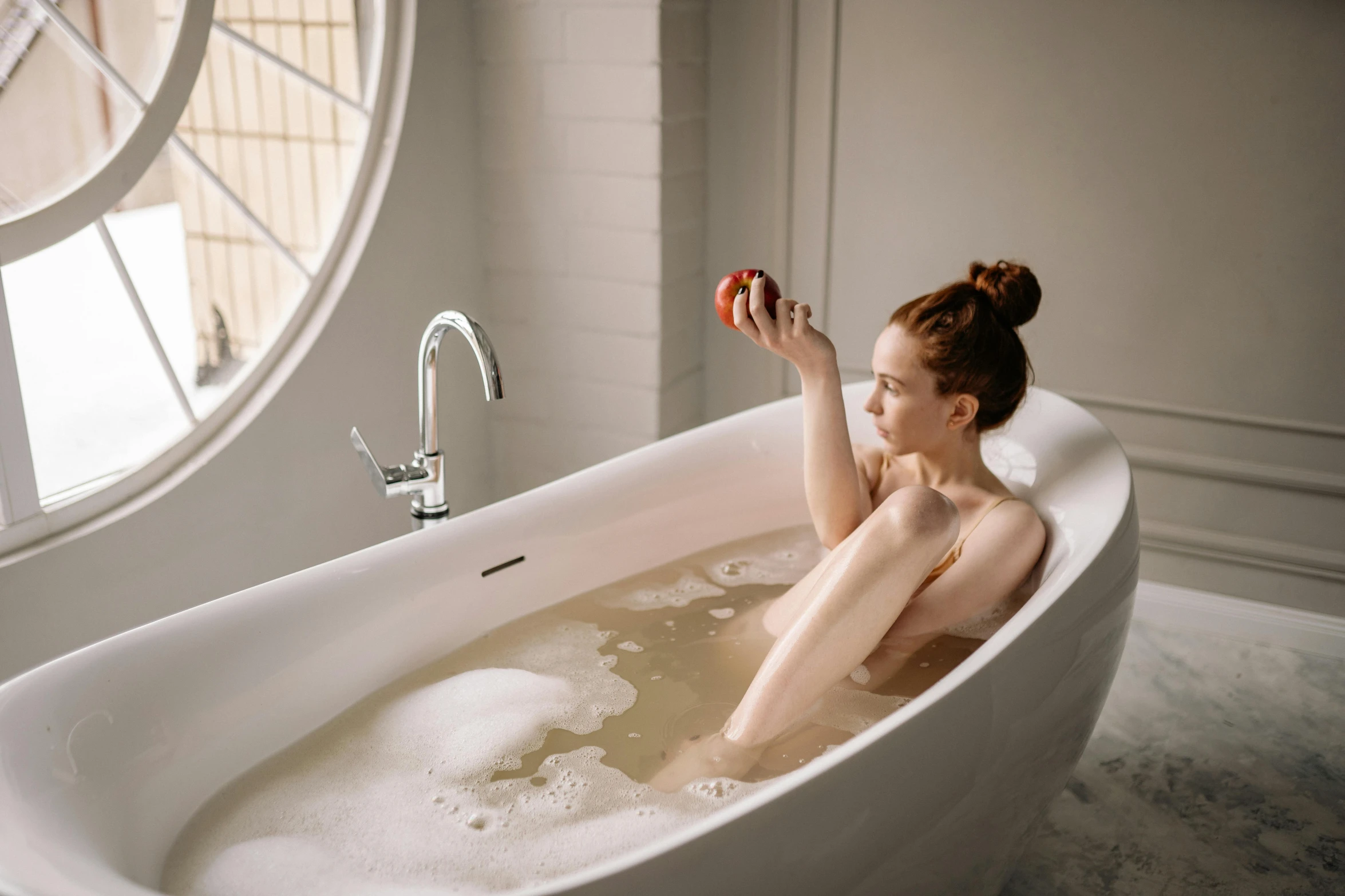 a woman sitting in a bathtub holding an apple, trending on pexels, renaissance, back arched, manuka, float, angled shot