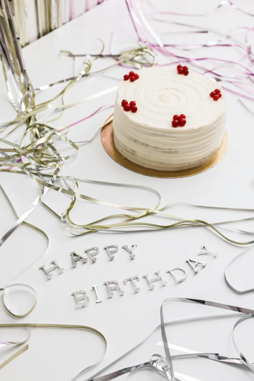 a birthday cake sitting on top of a table, a picture, detailed string text, white and silver, detailed product shot, scattered props