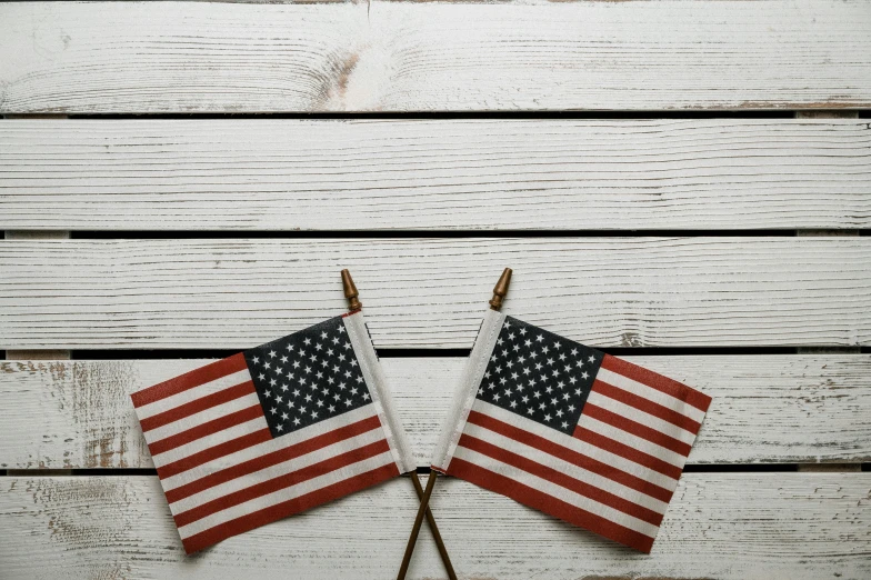 two american flags sitting on top of a wooden table, a portrait, unsplash, white, background image, small, instagram post