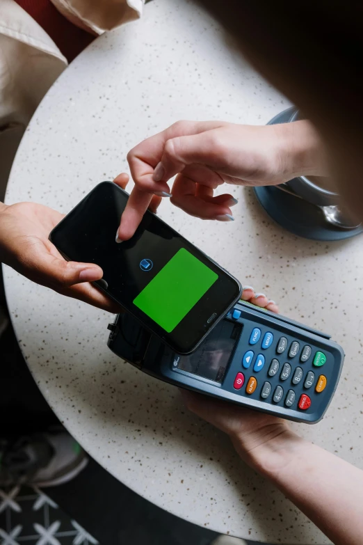 a person holding a cell phone with a green screen, cash register, visa pour l'image, square, high quality photo