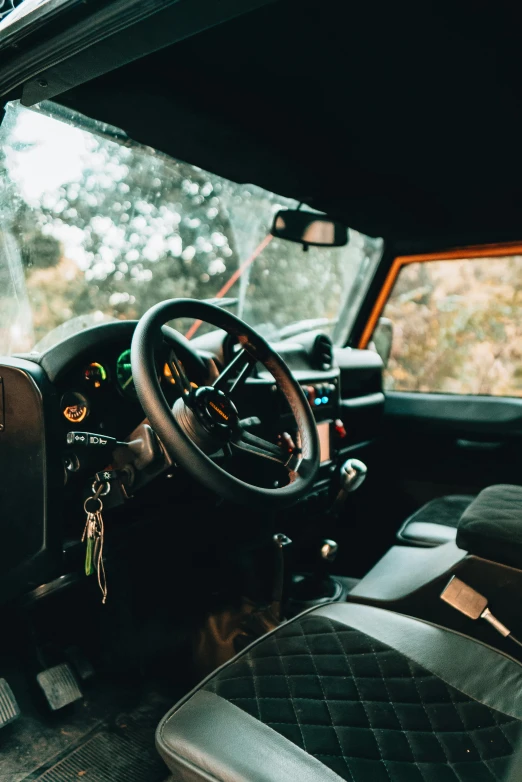 a close up of a steering wheel in a vehicle, a portrait, by Daniel Seghers, unsplash, land rover defender 110 (1985), wide shot of a cabin interior, square, mahindra thar