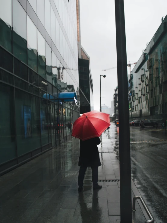 a person walking down a street holding a red umbrella, facing away, umbrella, snapchat photo, multiple stories