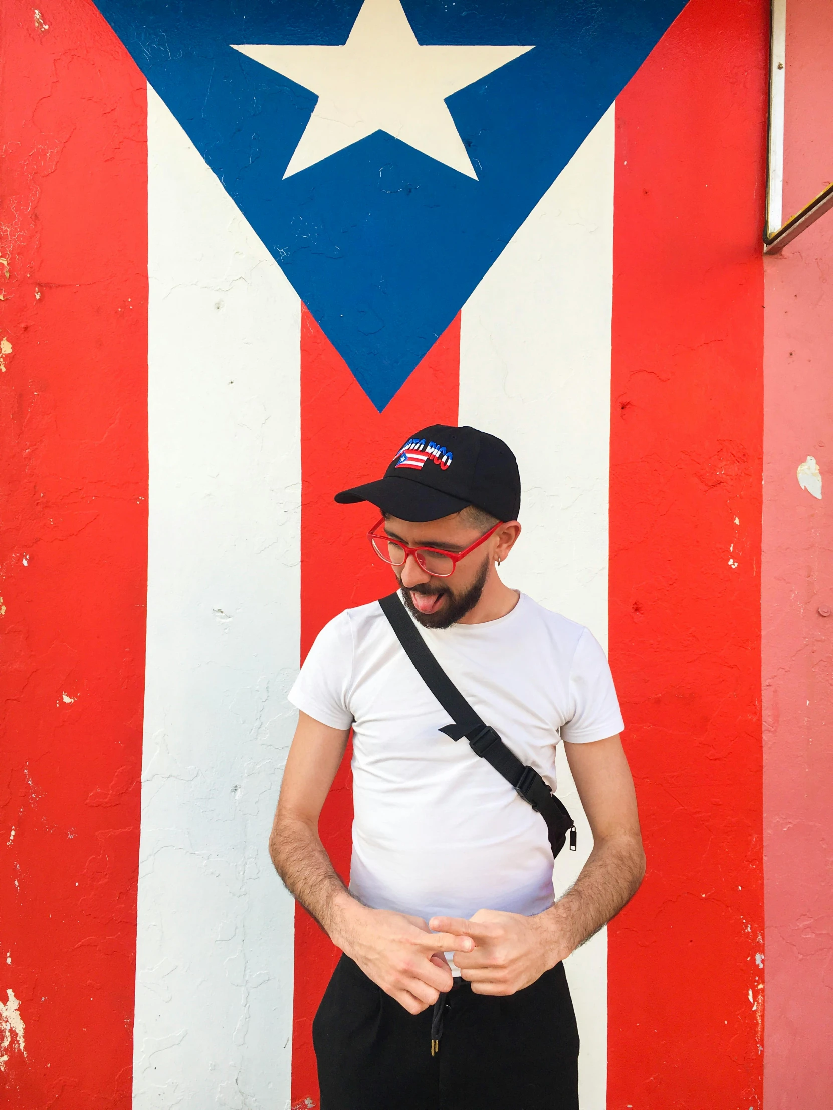 a man standing in front of a puerto rican flag, a photo, trending on reddit, pop art, black pointed hat, 2 5 6 x 2 5 6 pixels, tourist photo, lgbtq