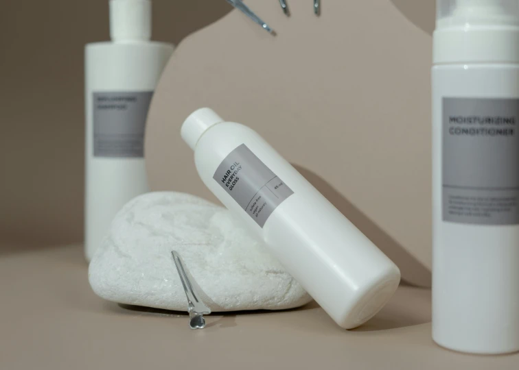 a couple of bottles of lotion sitting on top of a table, inspired by Marina Abramović, unsplash, plasticien, white cloud hair, silver，ivory, close-up product photo, cast