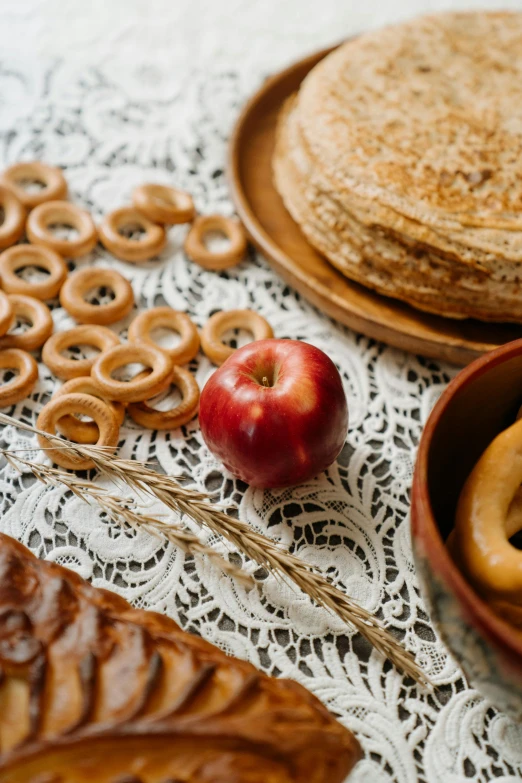 a close up of a plate of food on a table, a still life, by Adam Marczyński, pexels, bagels, apple, rye (shishkin), goldilocks