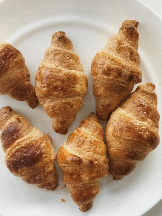 a white plate topped with croissants on top of a table