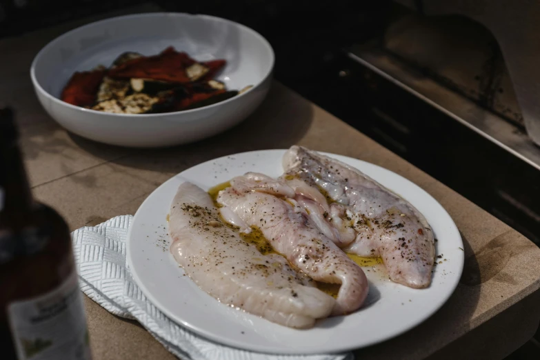 a close up of a plate of food on a table, fish in the background, barbecue, alessio albi, unfinished