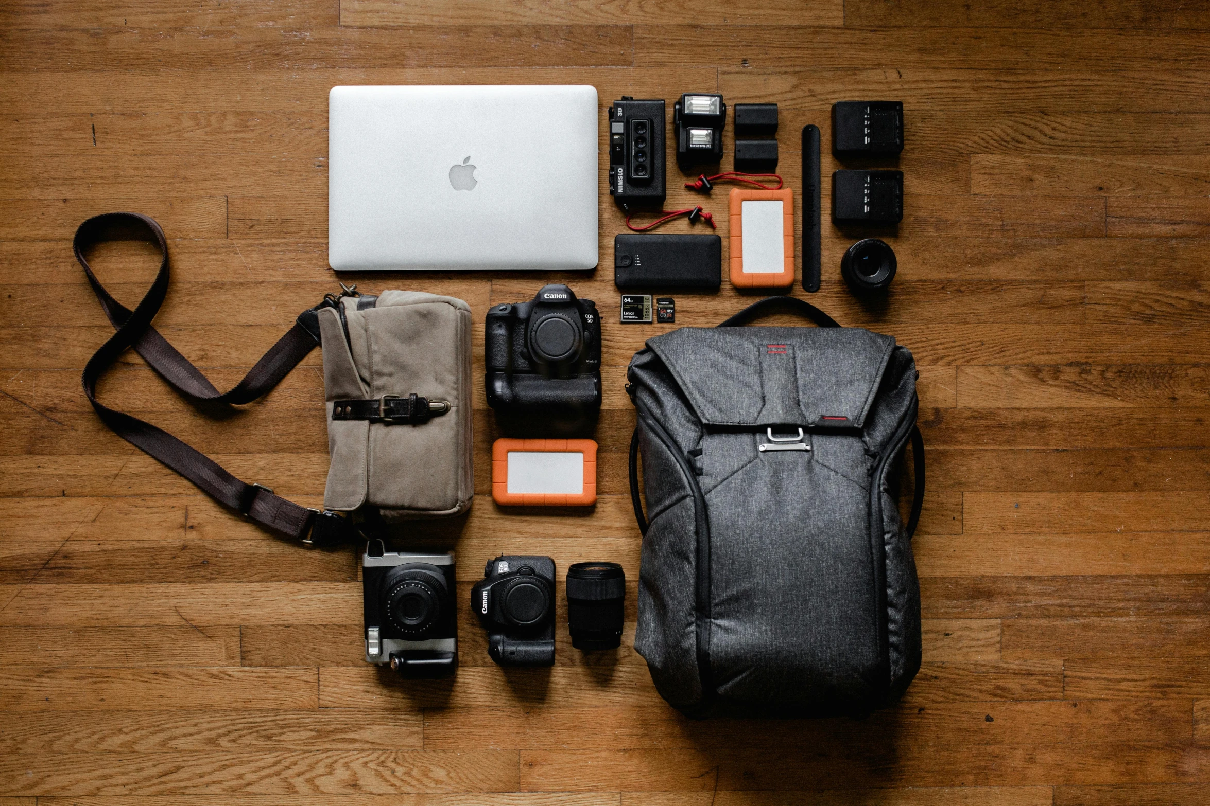 a bag sitting on top of a wooden floor next to a laptop, a picture, pexels contest winner, cameras lenses, knolling, airforce gear, thumbnail