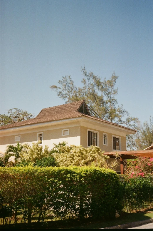 a large white house sitting on top of a lush green field, samburu, lush garden surroundings, sunfaded, brown