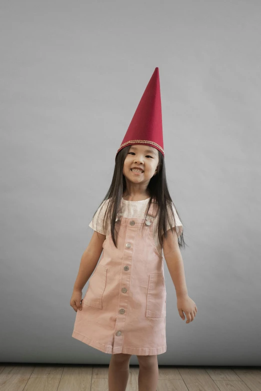 a little girl wearing a pink dress and a red hat, pexels contest winner, conceptual art, gnome, plain background, uniform, on