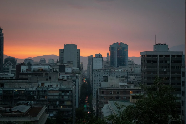 a view of a city at sunset from a high rise building, by Alejandro Obregón, unsplash contest winner, neoclassicism, chile, brutalism buildings, greece, background : diego fazio