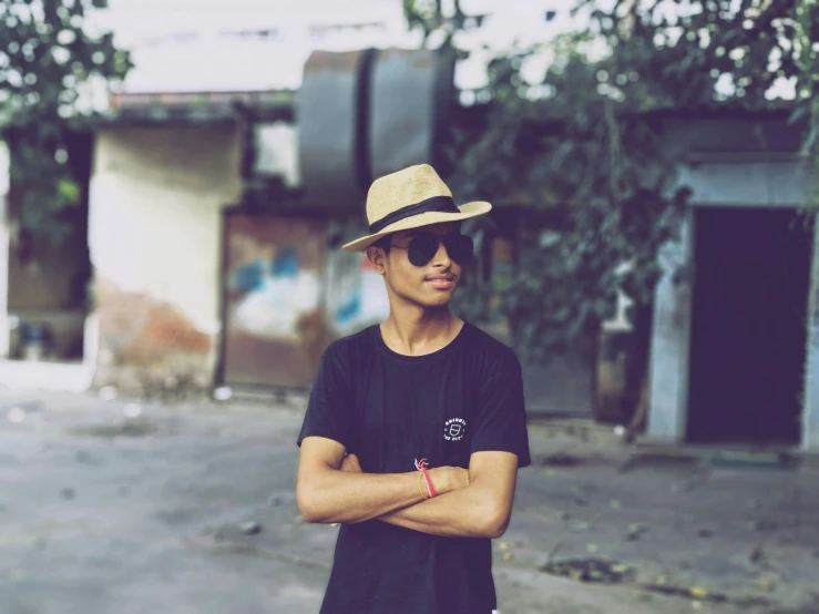 a man standing in the middle of a street wearing a hat, a picture, inspired by Byron Galvez, pexels contest winner, he is wearing a black t-shirt, assamese aesthetic, clean shaven, avatar image