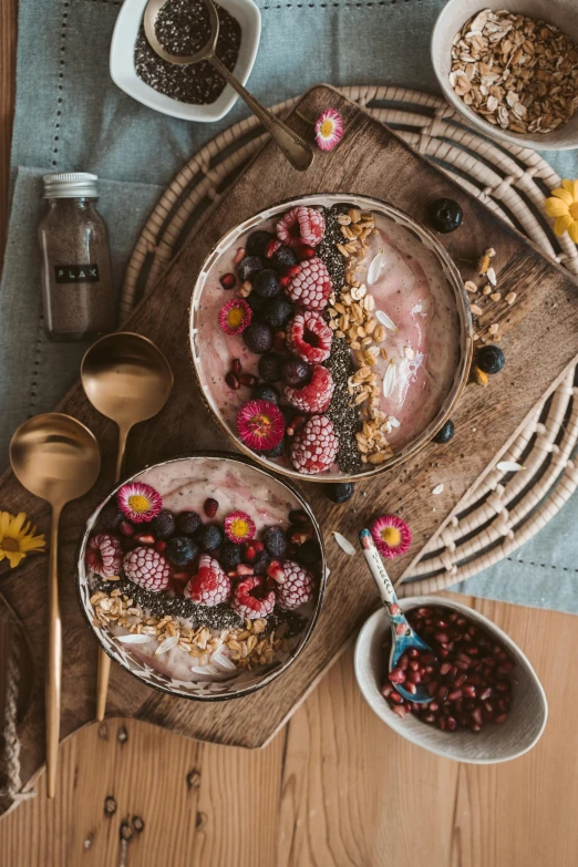 a table topped with bowls of food on top of a wooden table, a still life, trending on pexels, made of flowers and berries, pink, yogurt, bronze