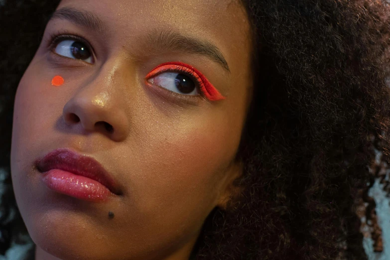 a close up of a person with bright makeup, an album cover, by Carey Morris, light red and orange mood, fluo details, promo image, gaze down