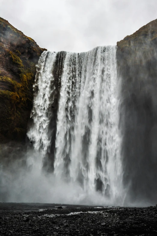 a man standing in front of a waterfall, highly turbulent, reykjavik, seen from below, photo taken in 2018