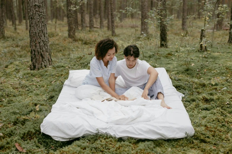 a man and a woman sitting on a bed in the woods, pexels contest winner, white sheets, thumbnail, modern, small bed not made