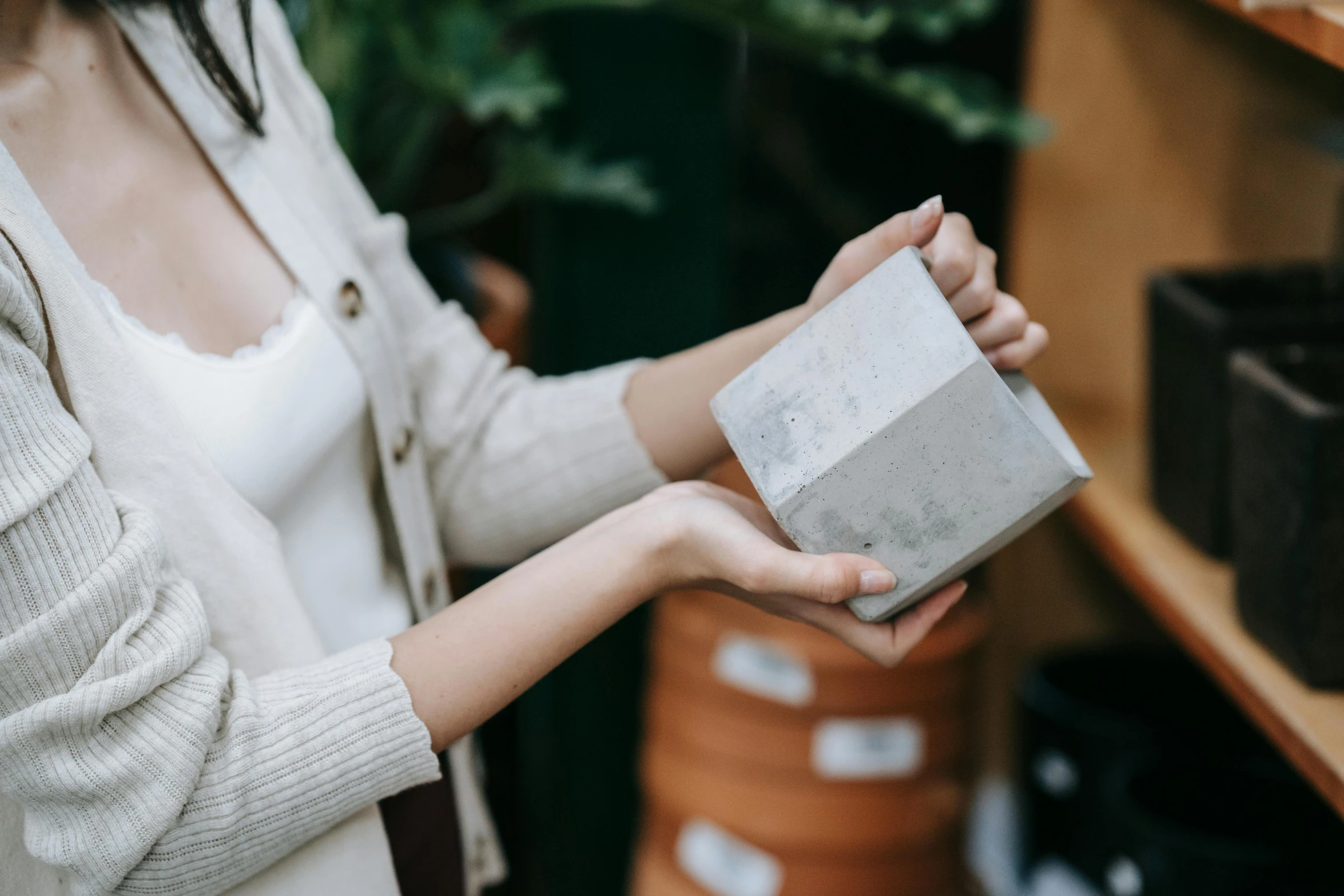 a woman holding a cement block in her hands, a marble sculpture, by Emma Andijewska, pexels contest winner, unique pot made for houseplants, inspect in inventory image, giving gifts to people, concrete building