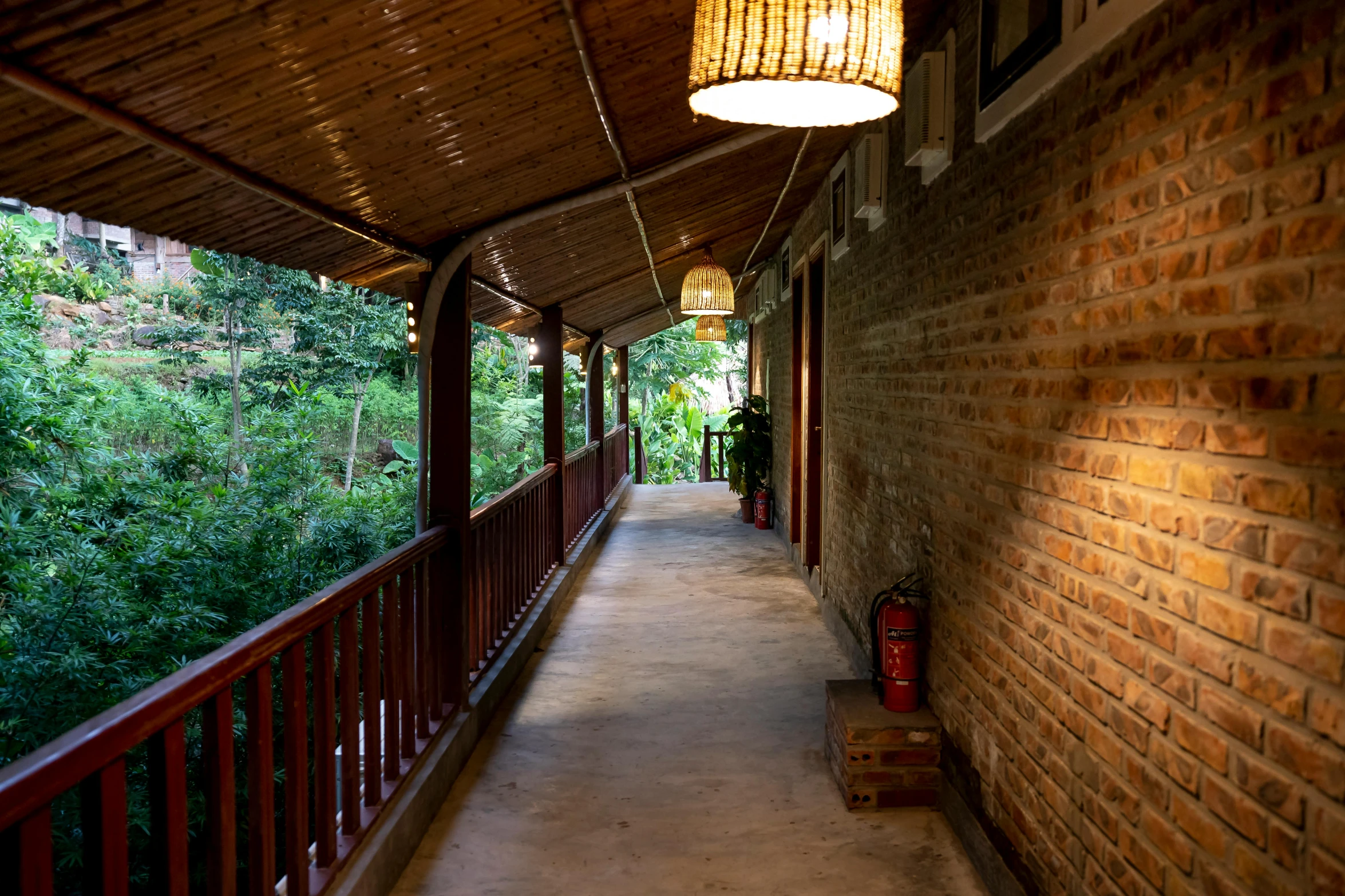 a walkway with a lamp hanging from the ceiling, lush forests, profile image, balcony, vietnam