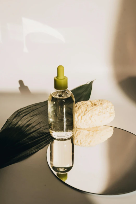 a bottle of liquid sitting on top of a glass table, by Olivia Peguero, skincare, healing pods, lush botany, cooking oil