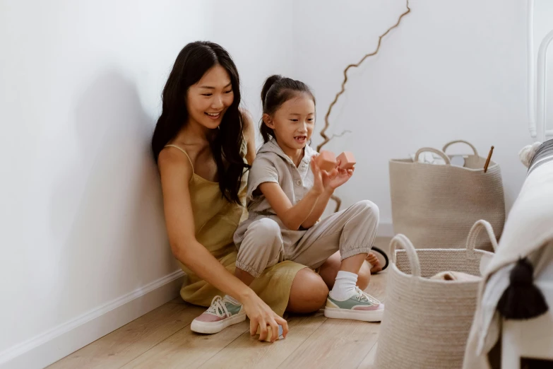 a woman and a child sitting on the floor, pexels contest winner, japanese collection product, with an easter basket, neutral colours, tan