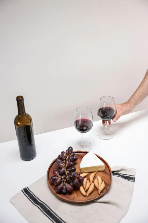 a man sitting at a table with a plate of food and a bottle of wine, curated collections, detailed product image, pouring, 4l