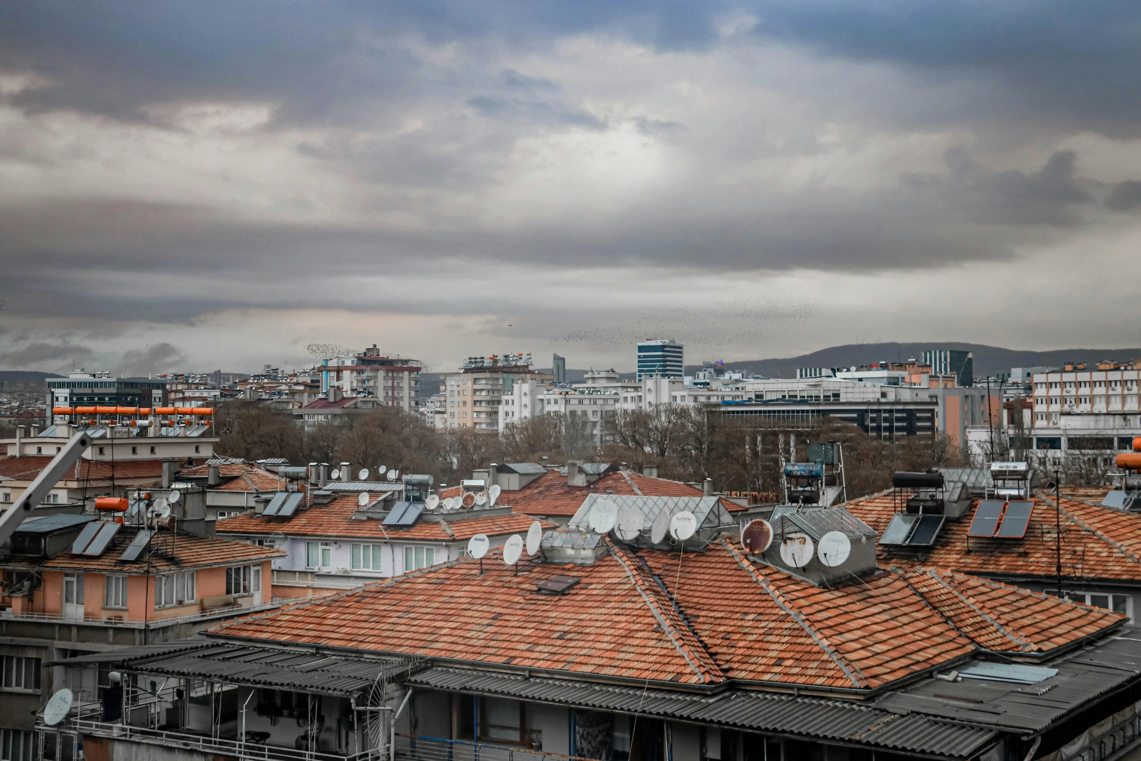 a view of a city from the top of a building, by Ibrahim Kodra, gray skies, tiled roofs, 7 0 mm photo