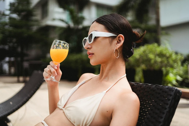 a woman in a bikini holding a glass of orange juice, inspired by Jacopo Bellini, pexels contest winner, renaissance, young asian woman, resort, holding a glass of wine, mid 2 0's female