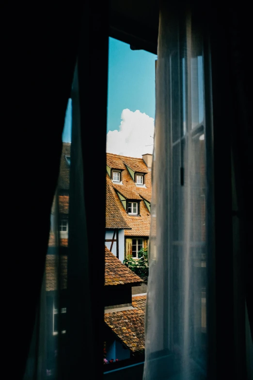 a view of a city from a window, by Tobias Stimmer, unsplash contest winner, renaissance, french village interior, curtains, normandy, low - angle shot from behind