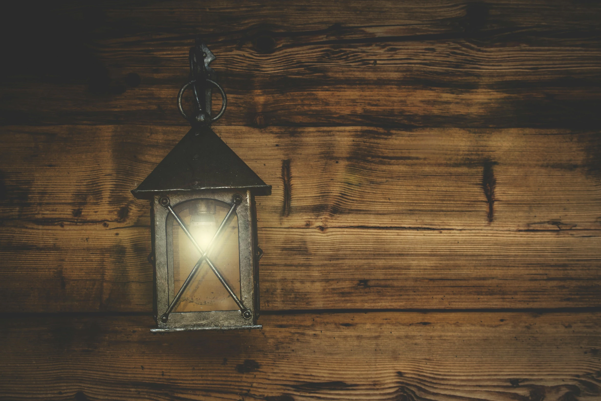 a lantern hanging from the side of a wooden wall, pexels contest winner, metallic light, background image, dusty volumetric light, listing image