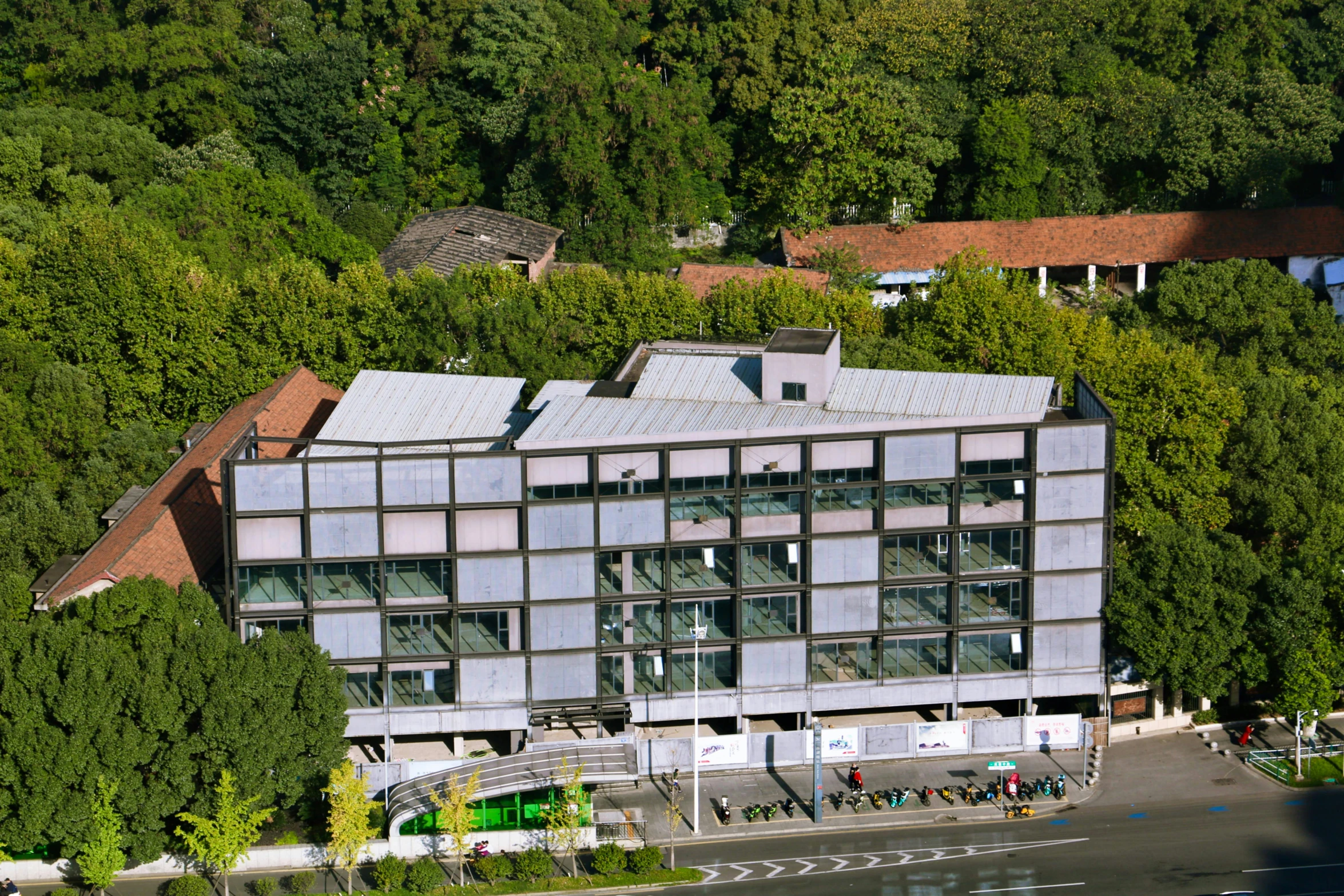 a large building sitting on top of a lush green hillside, inspired by Peter Zumthor, danube school, aerial photo, square, offices, award-winning”