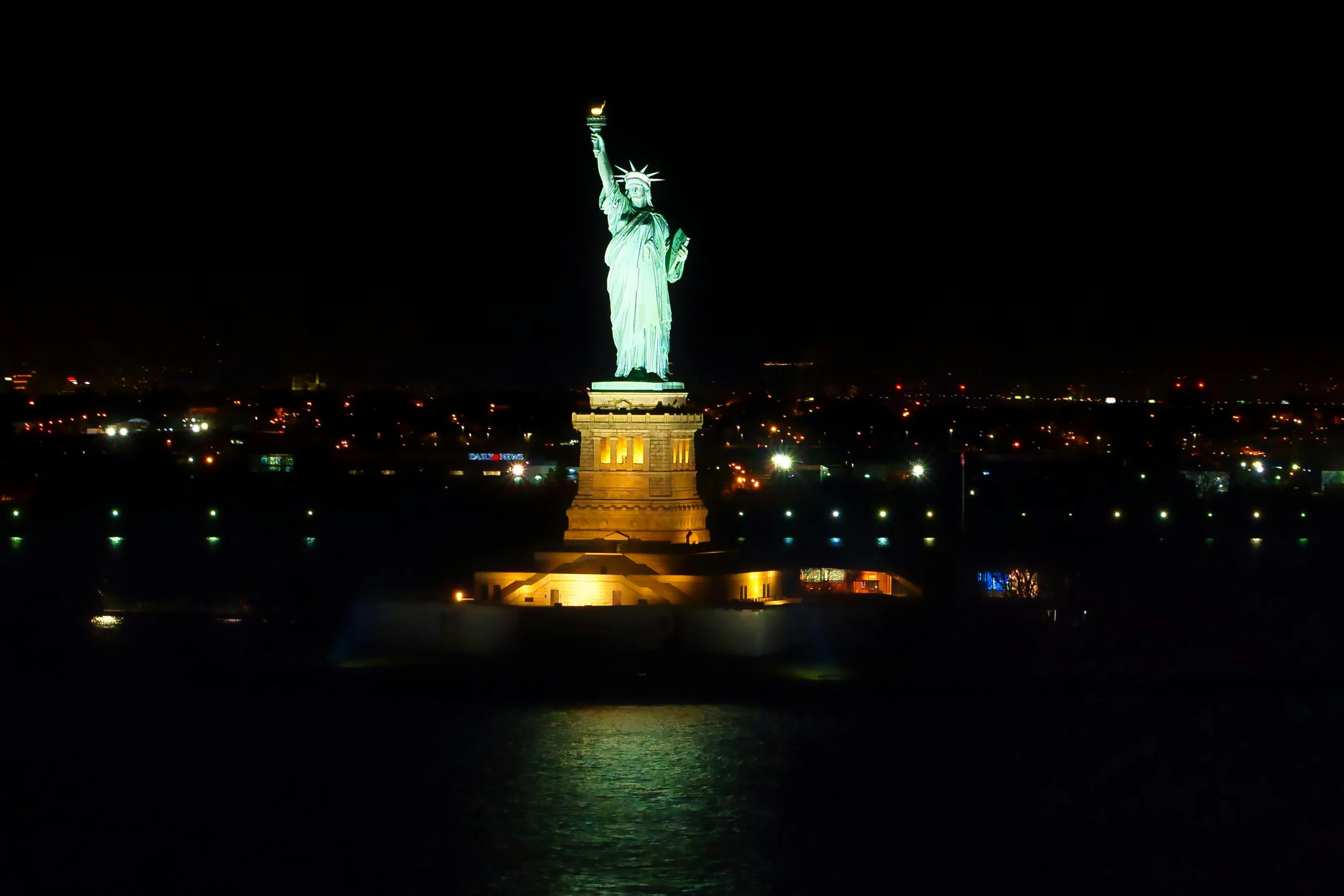 the statue of liberty is lit up at night, a statue, pexels contest winner, hurufiyya, 1999 photograph, small stature, shot on sony a 7, rectangle