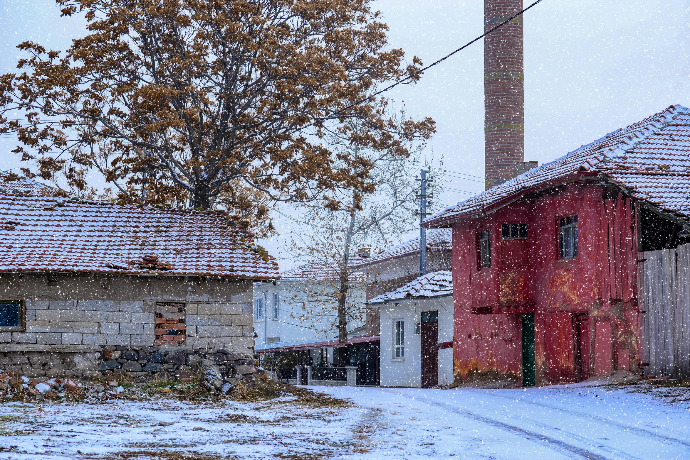 a red building sitting in the middle of a snow covered street, by Lucia Peka, pexels contest winner, hyperrealism, pamukkale, next to a farm house and a barn, autumn rain turkel, panorama