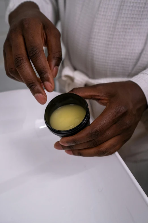 a close up of a person putting something in a bowl, natural complexion, product display photograph, liquid wax, serenity & calm