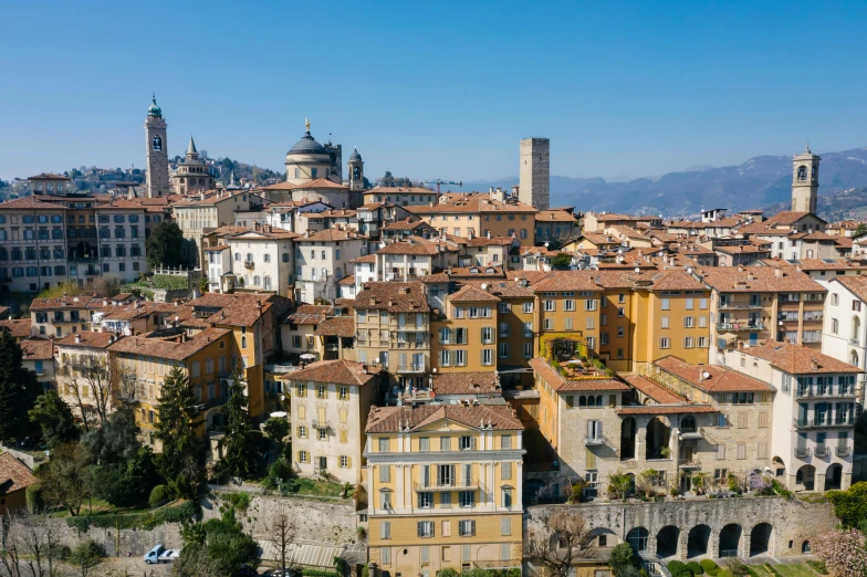 a group of buildings sitting on top of a lush green hillside, inspired by Raffeaello Ossola, pexels contest winner, renaissance, square, brown, skyline, bl