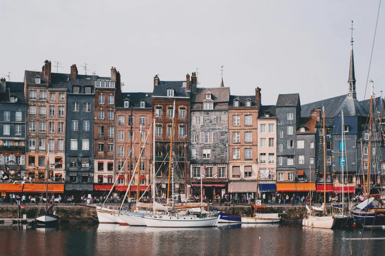 a number of boats in a body of water, by Raphaël Collin, pexels contest winner, art nouveau, small buildings, wearing a french beret, editorial image, granville chandor